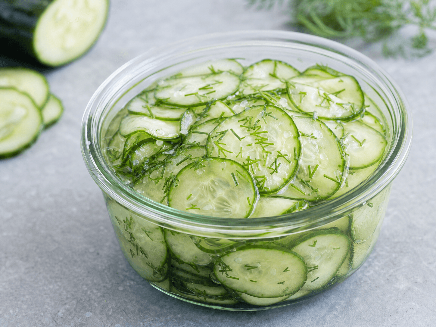 Agurkesalat med tynde agurkeskiver, dild og klar eddikelage i en skål