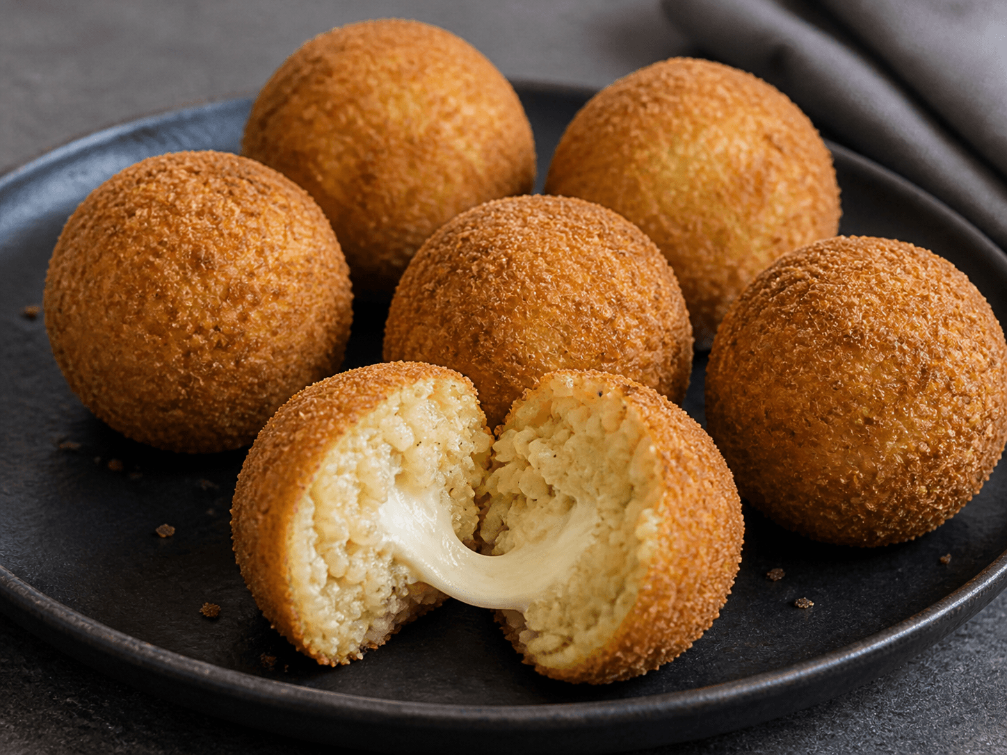 Gyldne arancini med sprød panering, risotto og smeltet mozzarella i midten
